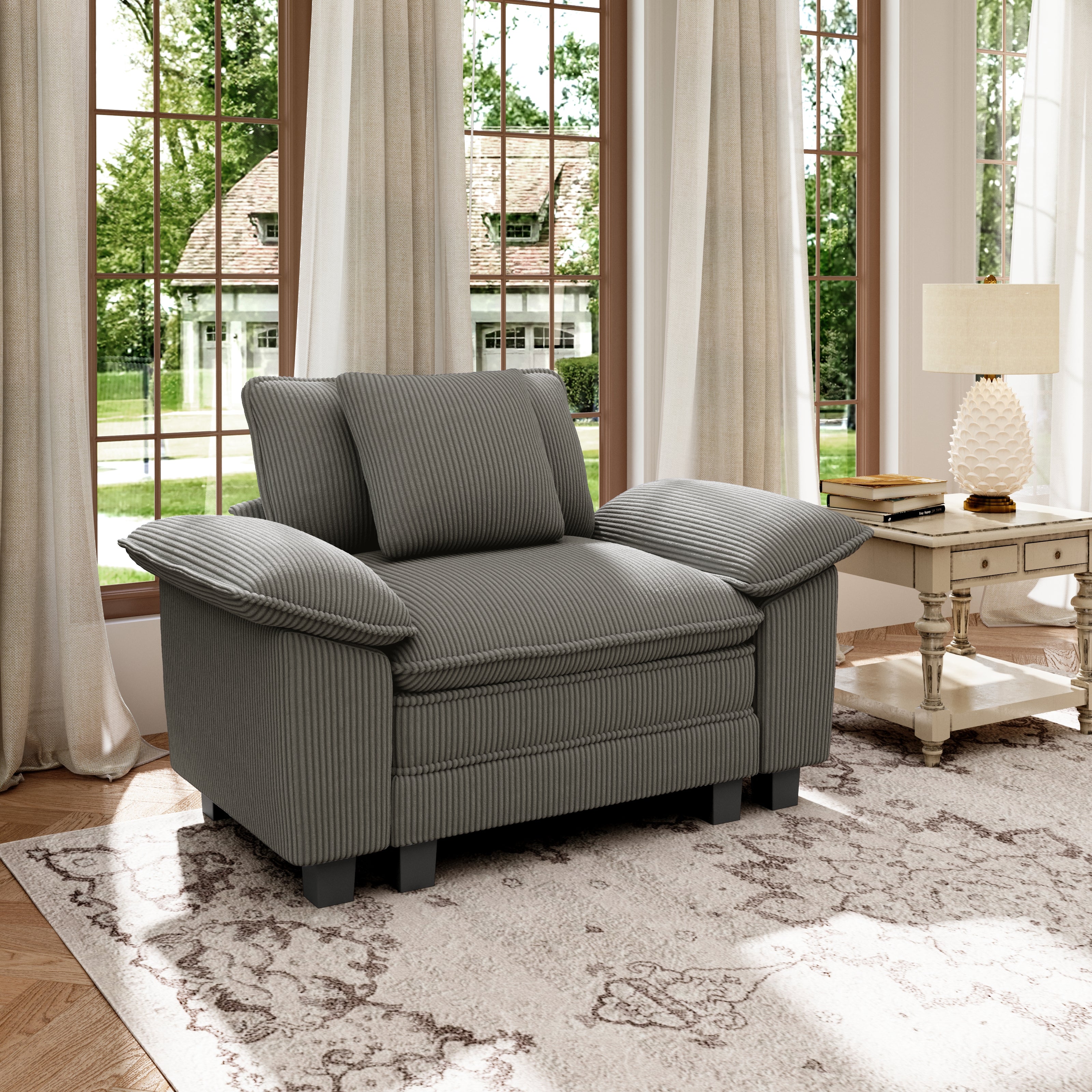 Gray corduroy sectional cloud couch in a living room with large windows and curtains.